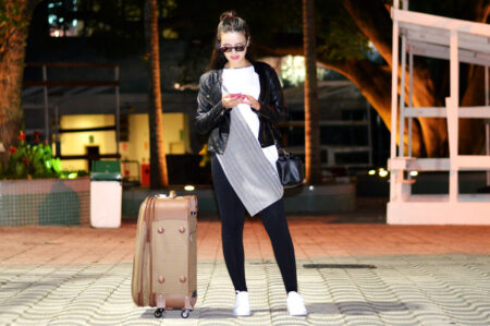mulher usando jaqueta de couro, camisa longa, legging e tênis