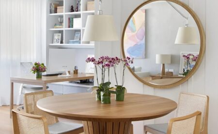 sala de jantar com mesa redonda e espelho redondo de madeira