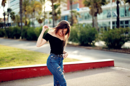mulher usando blusa ombro a ombro e caça jeans