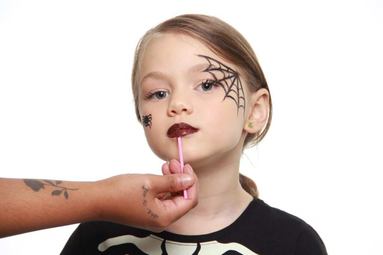 menina com teia de aranha desenhada no rosto