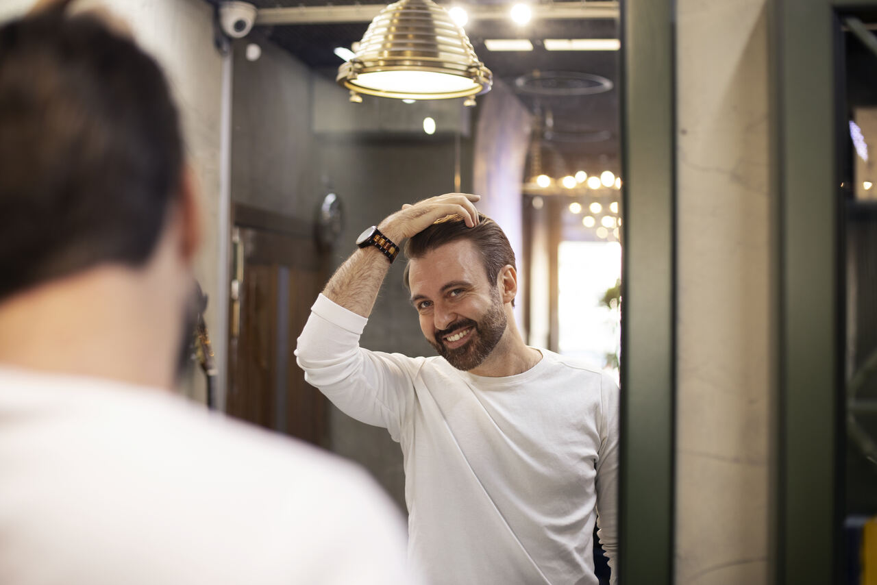 homem finaliza cabelo após passar pomada capilar