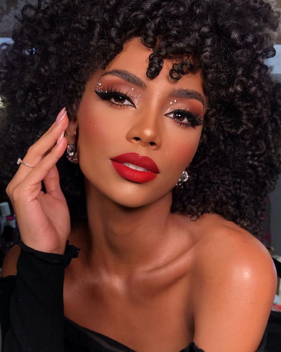 Modelo negra com maquiagem brilhante e batom vermelho