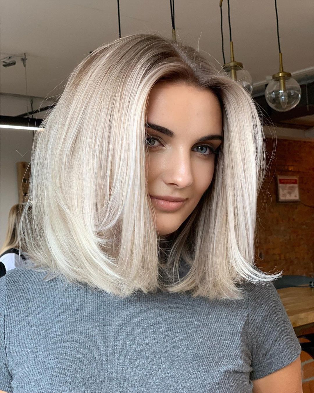 Mulher com corte long bob médio loiro platinado