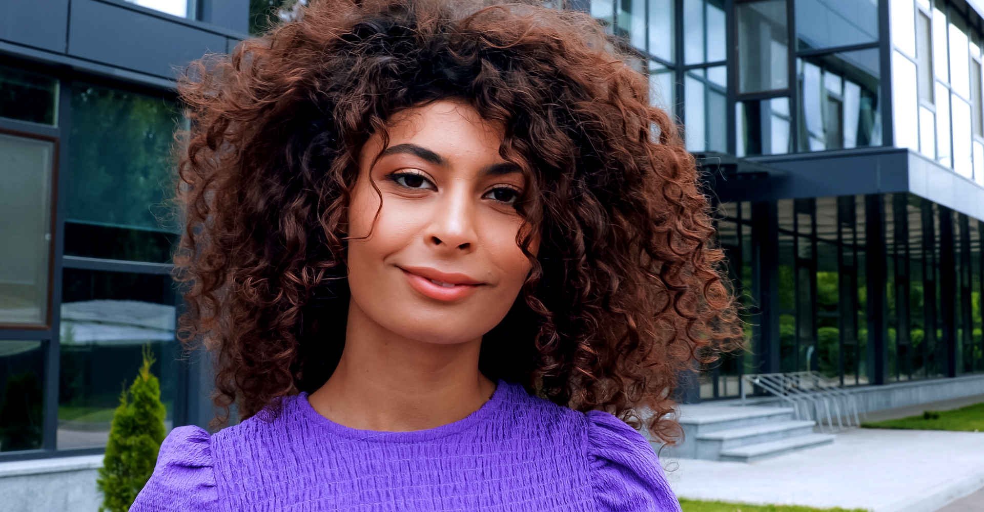 Mulher com corte long bob médio cacheado