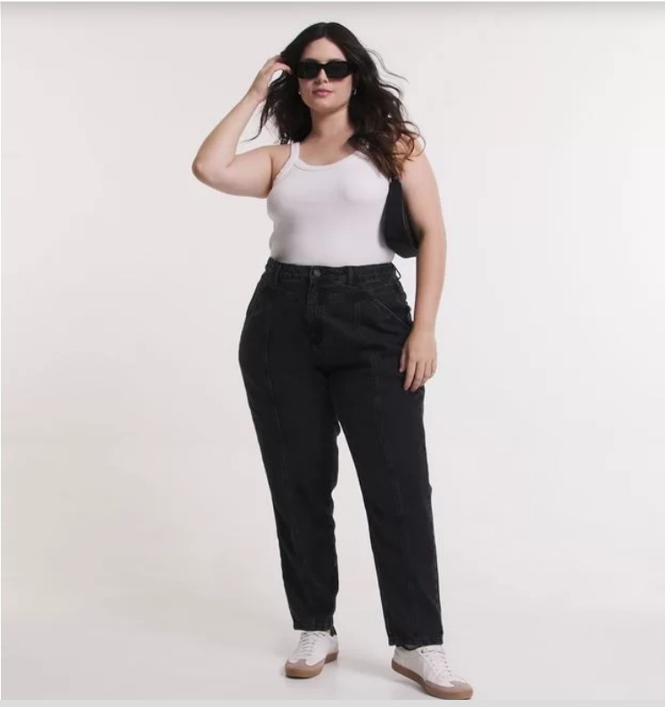Modelo veste calça mom jeans preta com regata branca