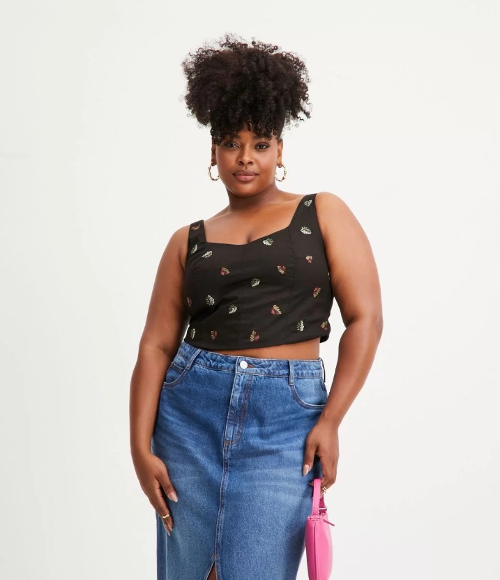 Modelo veste cropped preto com saia de cós alto jeans