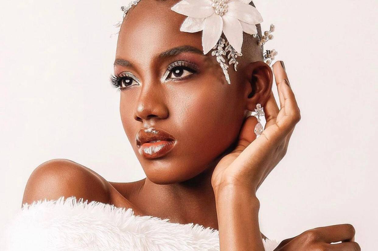 Noiva negra com maquiagem brilhante e acessório de cabelo em formato de flor