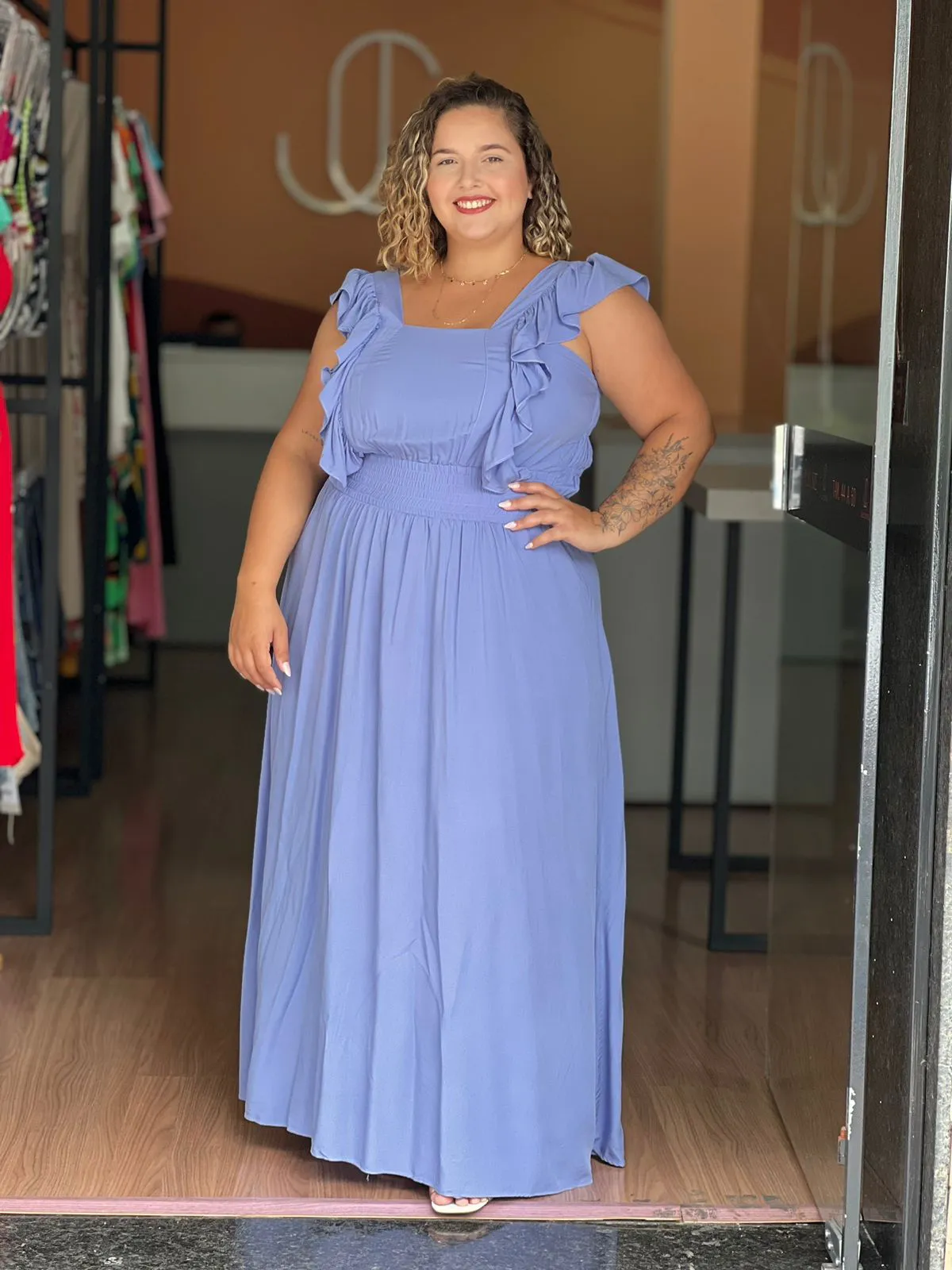 Modelo usando vestido plus size longo azul claro com babados