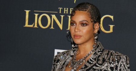Beyoncé é confirmada como anfitriã do Met Gala 2026; veja quem mais estará no evento Beyoncé, anunciada como anfitriã do Met Gala 2026, posa para fotos em evento de gala usando vestido bordado em tons escuros e joias prateadas, diante de painel promocional de premiação internacional