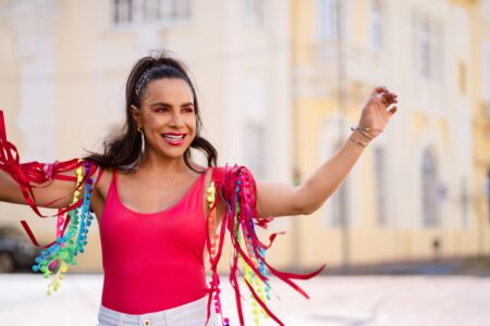 Abadá customizado feminino: tendências, modelos e guia de personalização abadá customizado feminino com franjas coloridas e aplicações artesanais, usado em look de Carnaval 2026 com maquiagem iluminada e visual alegre ao ar livre