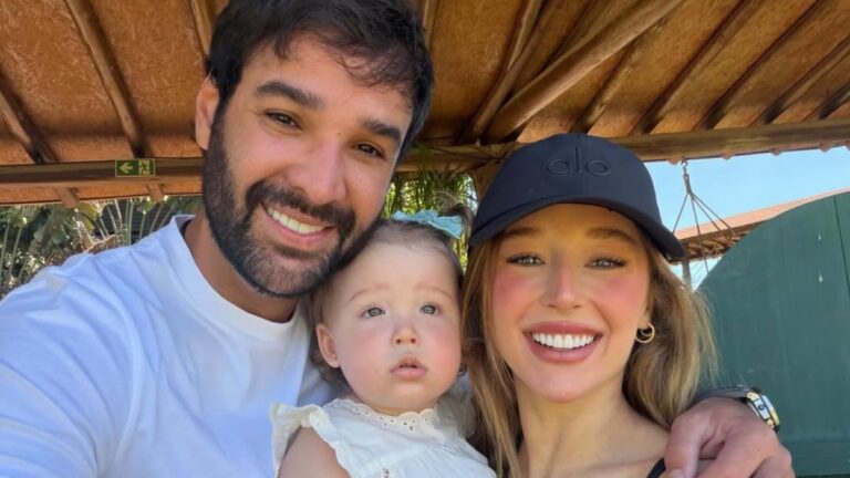 Duda Reis, Du Nunes e a filha Aurora posam juntos sorrindo em ambiente externo